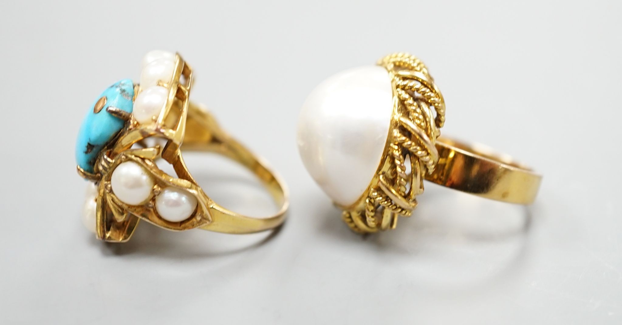 A 14k yellow metal and mabe pearl set dress ring and a similar split pearl and turquoise set dress ring, both size M, gross weight 21.7 grams.